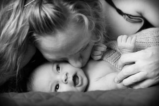 Mother kissing her smiling baby in Sacramento, California.