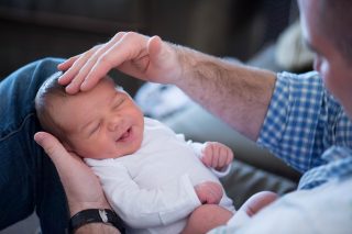 A new daddy looks at his newborn son basking in the love of his touch in Sacramento, California.
