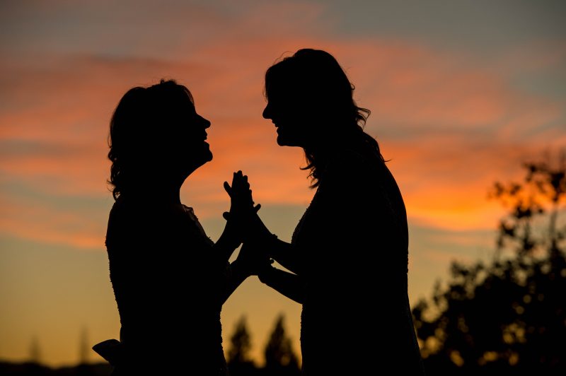 Two beautiful women enjoying the sunset together after their wedding at Las Positas Vineyards in Livermore, California
