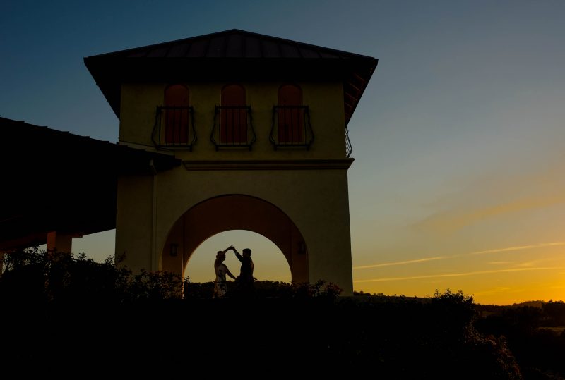 A silhouette of a couple dancing in the sunset during their wedding reception at David Girard Vineyards in Placerville, California.