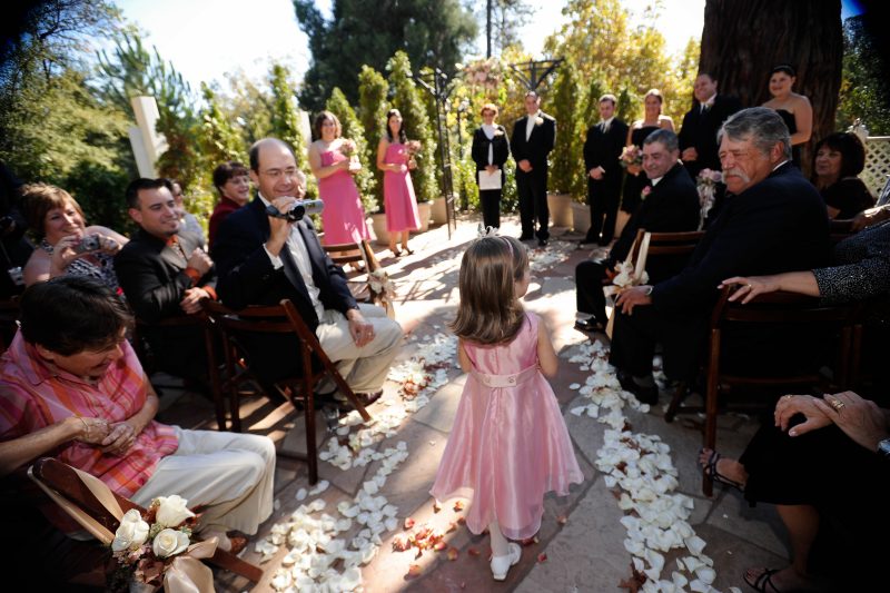 A flower girls walks down the aisle at a wedding at Sequoia Mansion in Placerville, CA