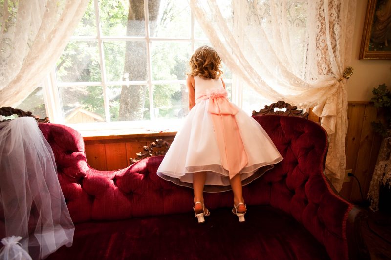 A flower girl is taking a peek out the window at Fausel Ranch in Placerville, CA